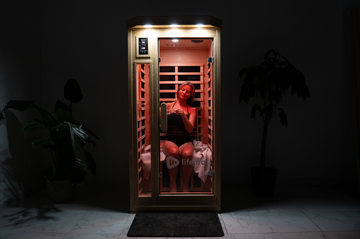 woman sitting in sauna with red light with dark background