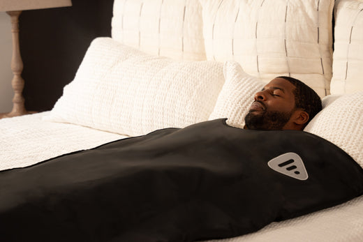 man laying in an infrared sauna on a bed