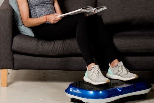 A Women reading book while using Waver vibration plate