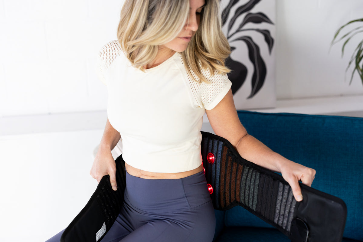 woman using red light therapy belt