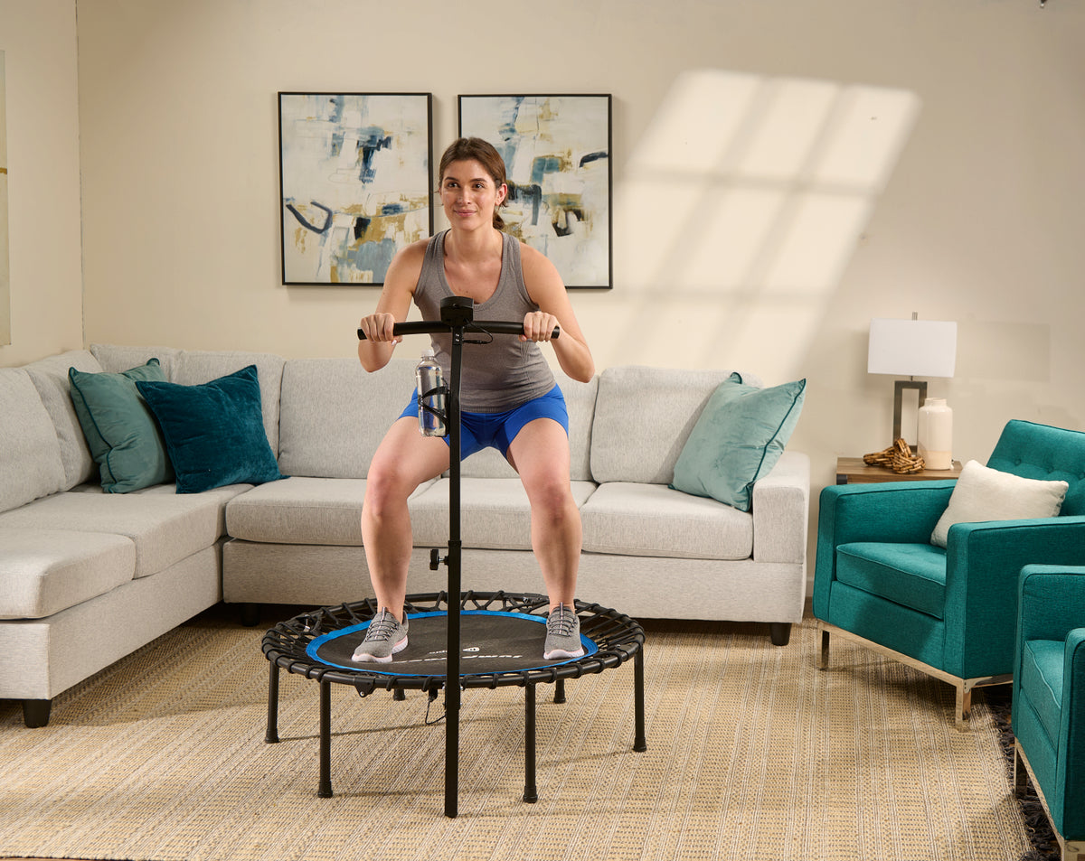 woman squatting while jumping on mini trampoline