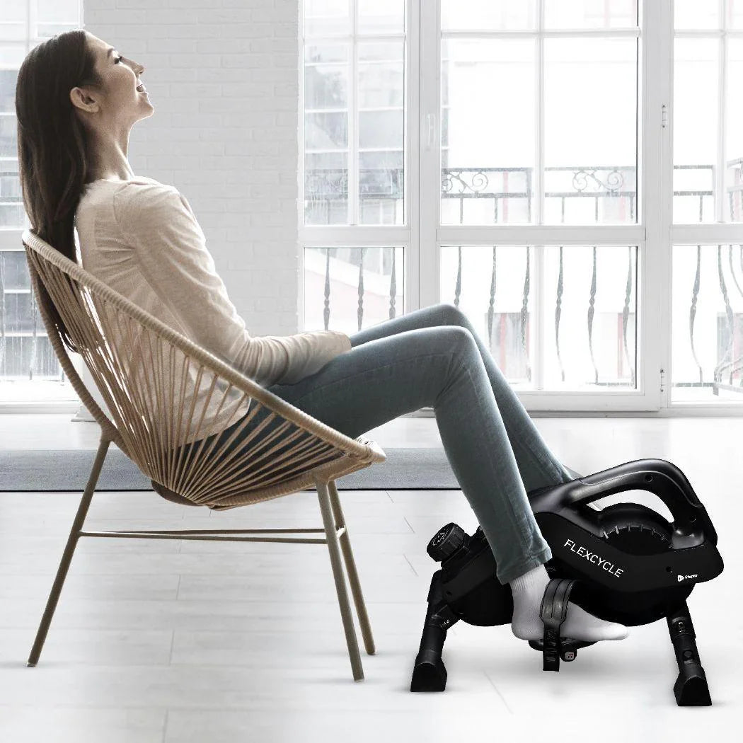 woman sitting in a chair using an under desk bike