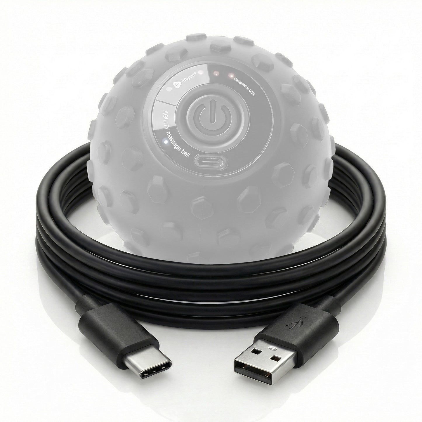 Black USB cable coiled next to a gray massage ball on a white background